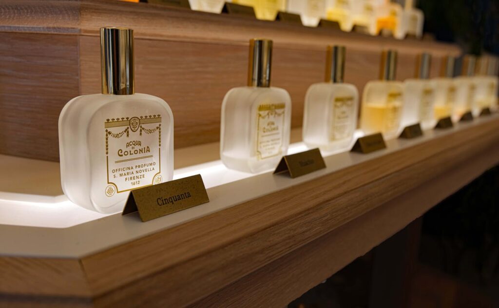Close-up of elegant luxury perfume bottles on a wooden shelf with ambient lighting.